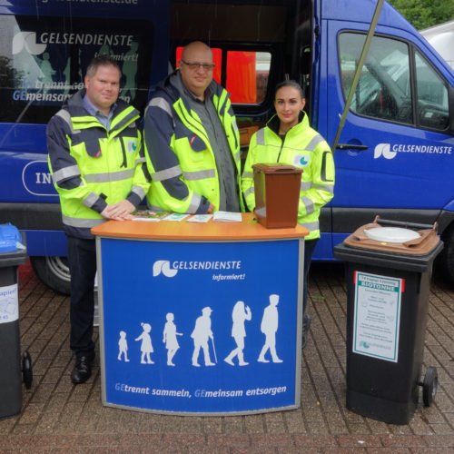 Die Mitarbeiterinnen und Mitarbeiter der GELSENDIENSTE Abfallberatung im Einsatz mit dem Infomobil auf dem Wochenmarkt in Ückendorf.