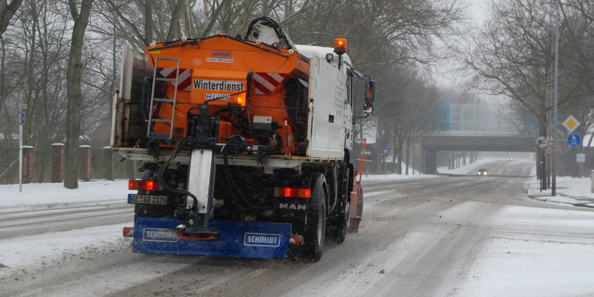 Streu- und Räumfahrzeug von GELSENDIENSTE im Winterdiensteinsatz auf der verschneiten Adenauerallee in Erle.
