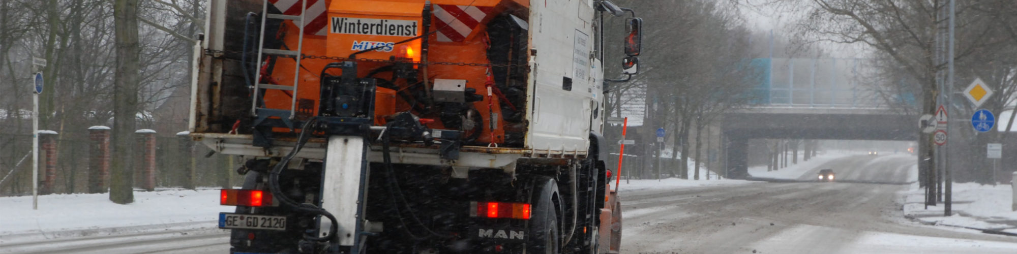 Streu- und Räumfahrzeug von GELSENDIENSTE im Winterdiensteinsatz auf der verschneiten Adenauerallee in Erle.