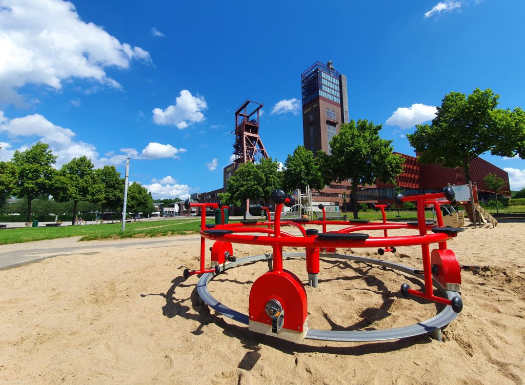 Ein Kinderspielplatz im Nordsternpark mit den Förderanlagen der ehemaligen Zeche im Hintergrund.