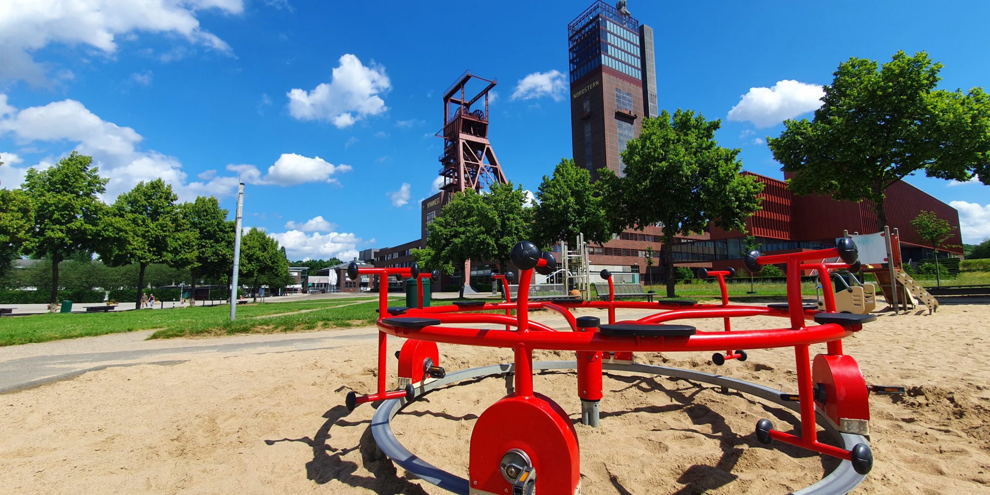 Ein Kinderspielplatz im Nordsternpark mit den Förderanlagen der ehemaligen Zeche im Hintergrund.